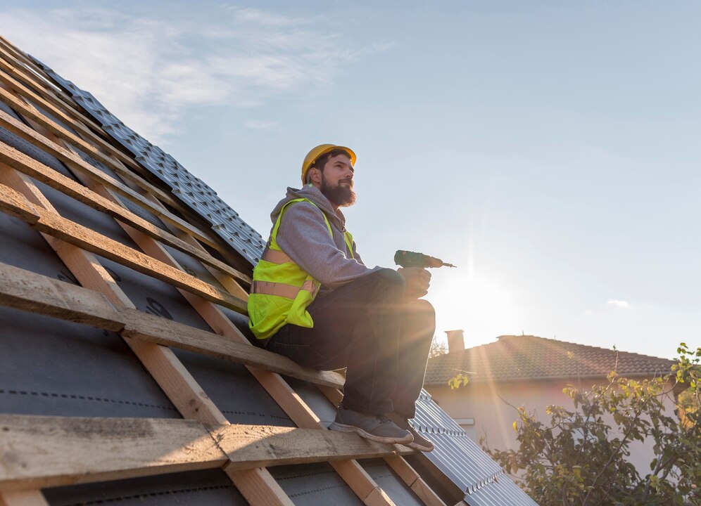 A man on the rooftop doing his work for roof repairs.